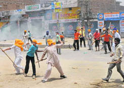 Agitators throw stones at the police on the Dabwali-Delhi highway following the death of one person in violence in Mandi Dabwali on Friday.