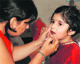 Readying for an act: Make up being applied on a kid during a function organised at Maple Bear Nursery School in Ludhiana on Friday.