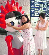 A Chinese woman hugs a robotic version of the Olympic Games Fuwa mascot one of the five roaming amongst passengers at the new International airport in Beijing on Friday.