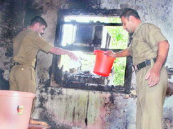 Fire officials douse flames by sprinkling water on a window pane in a house in Sector 22, Chandigarh