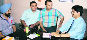 Dr Kishore C. Mukherjee interacts with members of a social organisation at Ahmedgarh on Sunday. 