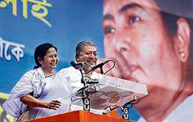 Trinamool Congress supremo Mamata Banerjee and former state chief of the NCP Somen Mitra smile as they attend a rally held to commemorate the death anniversary of party activists, in Kolkata on Monday.