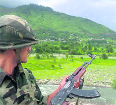 An army jawan stands guard on the Jammu-Poonch national highway near Mandi on the route to Budha Amarnath shrine in Poonch district. The security has been tightened in the area ahead of the pilgrimage next month.