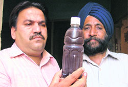 Rakesh Prashar, a councillor, shows muddy water from a tap in Ludhiana