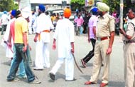 Activists of the All-India Sikh Students Federation block traffic and brandish kirpans at PAP Chowk in Jalandhar on Wednesday.
