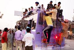 Bursting at the seams: Passengers climb an overcrowded bus in Bathinda