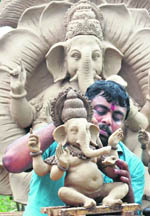 An artist gives final touches to an idol of Lord Ganesha at a workshop in Chandigarh