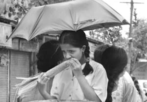 A schoolgirl enjoys a corn while returning from school in Ambala City on Thursday. 