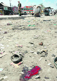 A jawan stands near the scene of a grenade explosion in Srinagar on Thursday. Five members of a family were killed in the explosion.