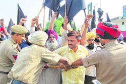 PSEB employees wave black flags during an inauguration programme by Chief Minister Parkash Singh Badal in Amritsar
