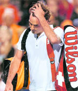 Roger Federer walks off the court after losing to Gilles Simon in the Rogers Cup in Toronto on Wednesday.