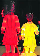 A Chinese worker checks colourful terracotta figured lanterns of a child and a woman in Beijing on Thursday.