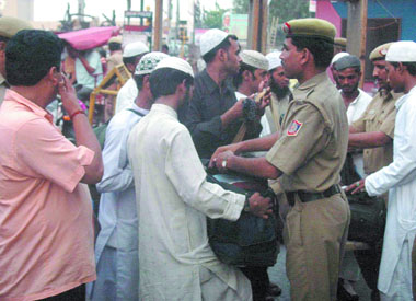 Policemen frisk the baggage of a group of people at Paharganj following high alert issued in the Capital after the Bangalore serial blasts in New Delhi on Friday.