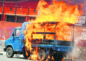 A police vehicle burns after demonstrators set it on fire during a protest in Jammu on Friday