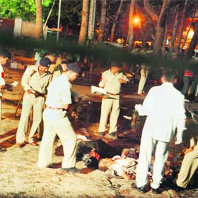 Policemen inspect the scene of a blast outside the trauma ward of the Civil Hospital in Ahmedabad