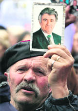 A file photo shows an elderly Serb man holding a picture of former Bosnian Serb leader Radovan Karadzic outside the US Embassy during a protest against a UN plan for the future status of Kosovo that caused gridlock on the streets of Belgrade.