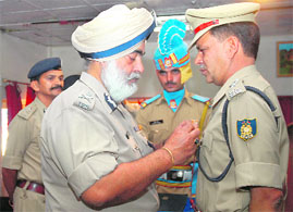 Additional CRPF director-general Karamvir Singh confers the D-Gs bravery commendation disc award on an officer for fighting against militancy at the raising day celebrations in Srinagar on Sunday.