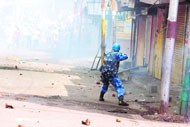 A policeman fires tear gas shells at agitators in Jammu on Monday. 