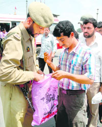 Security personnel check the bag of a man at the Hari Singh High street in Srinagar on Monday. 