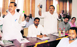 Councillors show bottles carrying contaminated water during the MC general house in Ludhiana on Monday.