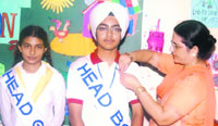 Principal Manjeet Kaur pins a badge on Gurpreet Singh in Ludhiana on Monday.