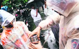 A policeman inspects a tiffin box outside the Bombay Stock Exchange in Mumbai on Monday. Security was tightened in and around the exchange after an email, claiming responsibility for the July 26 serial bomb attacks has mentioned the BSE as their next target.
