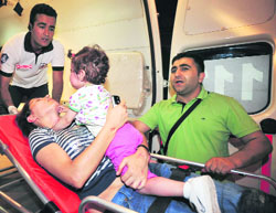 A woman, who was injured in a bomb blast, embraces her child as she is taken into an ambulance in Istanbul on Sunday. 