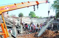 A JCB machine clears the debris from the spot.