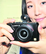 An employee of Japan's electronics giant Matsushita Electric Industrial displays the company's new digital camera "Lumix LX3" with optional view finder in Tokyo on Wednesday.