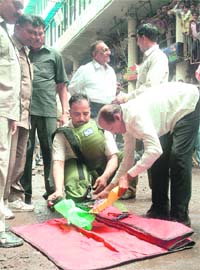 Bomb disposal squad officials gather around a defused bomb in Surat