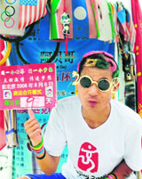 Olympics fan Sun Dingguo gestures from his bicycle the countdown with nine days to go to the start of Games