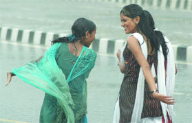 Girls enjoy in the rain in New Delhi on Thursday.