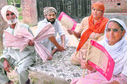 Baljinder Singh and his family seek comfort from oppressive heat with hand fans under a tree at Jatana Uchha village, near Samrala, on Thursday.