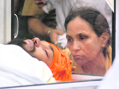 Ishmeets mother looks at him one last time as he lies in a glass casket in Ludhiana on Thursday.