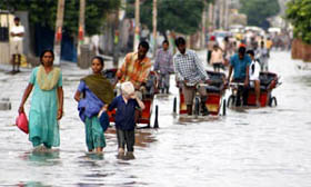 People wade through knee-deep water on Power House road in Bathinda following showers on Friday. The rains brought a welcome respite from the heat but caused waterlogging. 