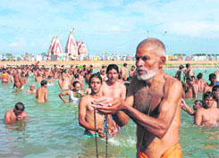 A devotee offers prayers during the solar eclipse at the Brahmsarovar in Kurukshetra on Friday.