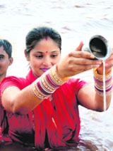 A woman offers prayers in the Tawi river during the solar eclipse in Jammu