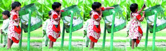 A child looks for a plaything in a litter bin on the lawn at India Gate in New Delhi on Sunday.