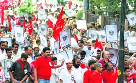 CPM party workers hold portraits of Harkishan Singh Surjeet during his funeral procession in New Delhi