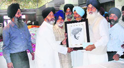 Chief Minister Parkash Singh Badal (right) presents a painting of Ishmeet Singh to his father in Ludhiana