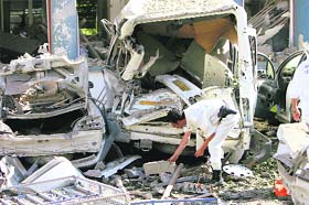 A bomb disposal expert collects evidence at the site of a blast outside a police station in Tizi Ouzou, east of Algiers