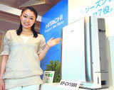 An employee of Japans electronics giant Hitachi displays the new high-performance air purifier Cleair, equipped with various sensors of dust, odour, humidity and temperature in Tokyo