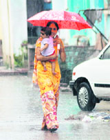 A woman walks through heavy rain in Karnal 