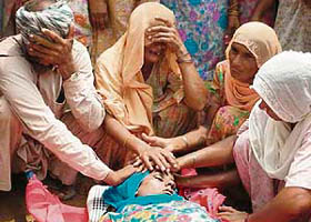 Grief-stricken parents and relations of Kiran, a victim of the Naina Devi stampede, at their residence at Lelewala village, near Talwandi Sabo, on Monday morning before the cremation.