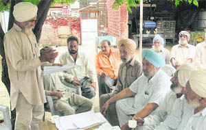 Residents of Sarangpur village discuss the low land compensation rates by the Chandigarh administration.