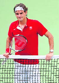 Roger Federer of Switzerland attends a training session at the Olympics Green Tennis court in Beijing