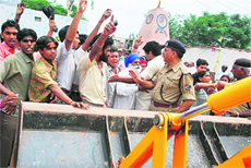 Residents block a JCB machine during a demolition drive in Zirakpur on Wednesday.