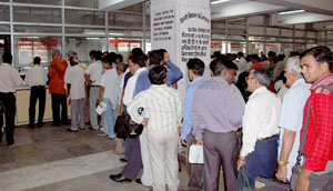 People queue up to collect DDA residential scheme forms at Vikas Sadan in New Delhi on Wednesday. 