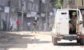 Protesters stone a vehicle carrying security personnel in Srinagar.