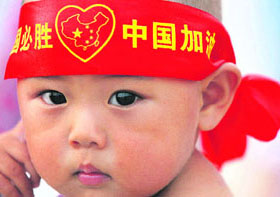 A Chinese baby with a headband reading "China must win. Go China" looks on at Tiananmen Square in Beijing on Wednesday, two days ahead of the 2008 Beijing Olympic Games.